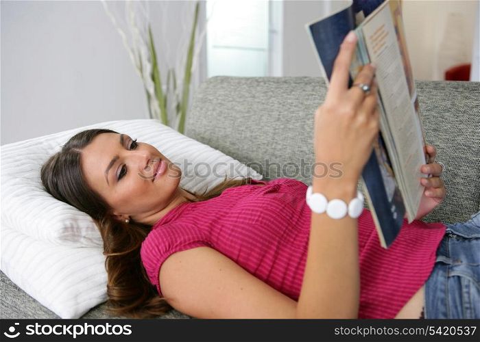 woman reading magazine on the couch