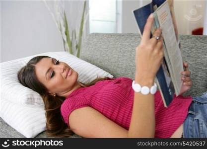 woman reading magazine on the couch