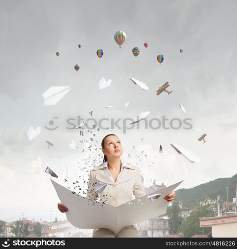 Woman reading newspaper. Portrait of young businesswoman in white suit reading blank newspaper