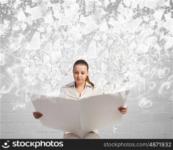 Woman reading newspaper. Portrait of young businesswoman in white suit reading blank newspaper