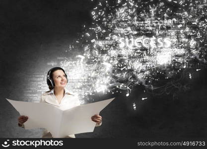 Woman reading newspaper. Portrait of young businesswoman wearing headphones and reading blank newspaper