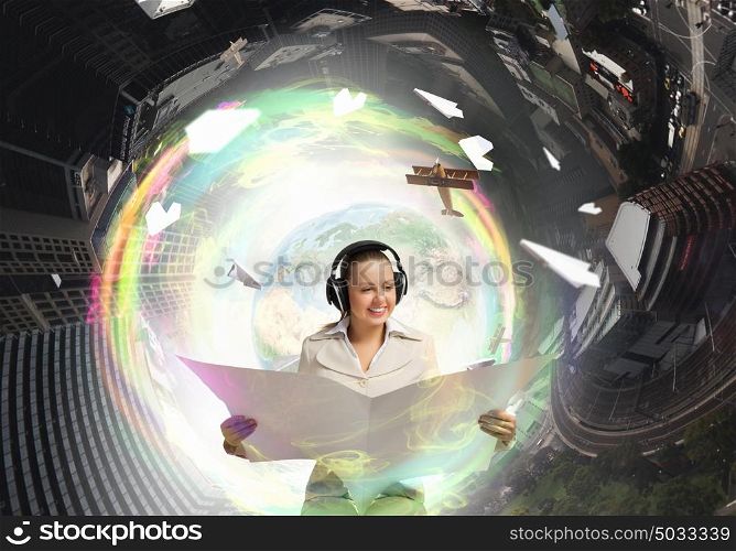Woman reading newspaper. Portrait of young businesswoman wearing headphones and reading blank newspaper