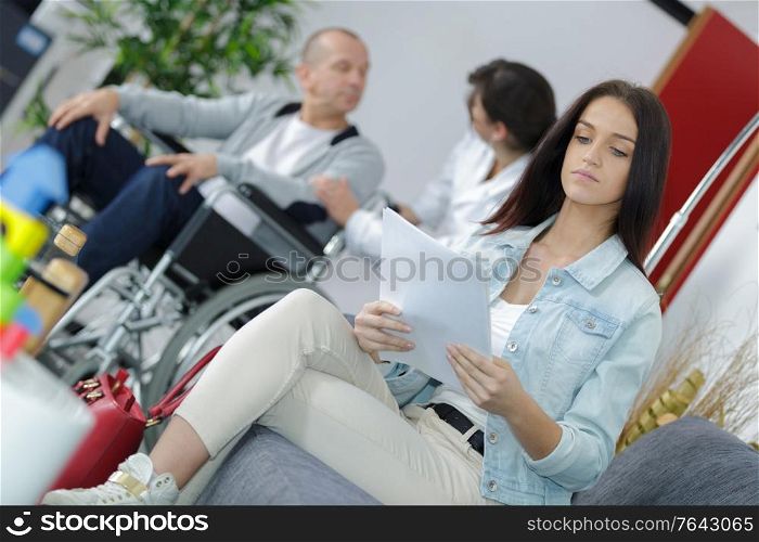 Woman reading paperwork in waiting room