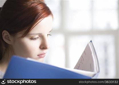 Woman reads blue file