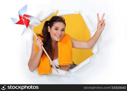 woman ready for the beach holding a paper wind mill