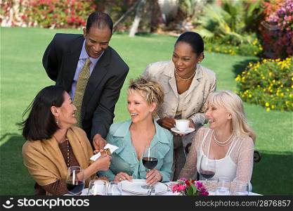 Woman receiving present from friends outdoors