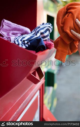 Woman Recycling Clothes At Clothing Bank