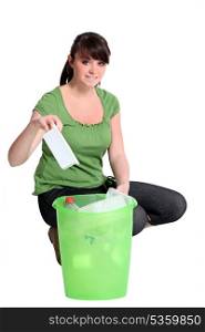 Woman recycling plastic
