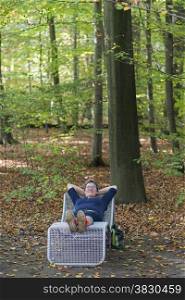 woman relax in autumn forest laying on a chair