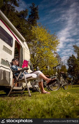 Woman relaxes and reads a book near the camping . Caravan car Vacation. Family vacation travel, holiday trip in motorhome.