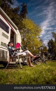 Woman relaxes and reads a book near the camping . Caravan car Vacation. Family vacation travel, holiday trip in motorhome.