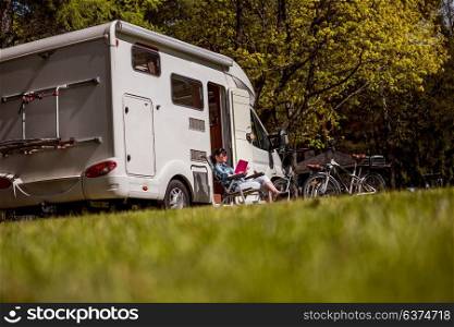 Woman relaxes and reads a book near the camping . Caravan car Vacation. Family vacation travel, holiday trip in motorhome RV.