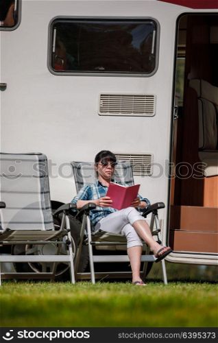 Woman relaxes and reads a book near the camping . Caravan car Vacation. Family vacation travel, holiday trip in motorhome RV.