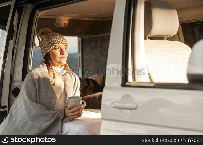 woman relaxing car while road trip holding mug