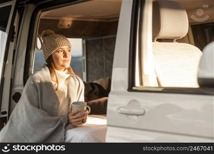 woman relaxing car while road trip holding mug