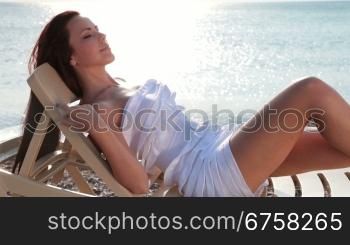 woman relaxing in a chair, enjoying a view at the beach