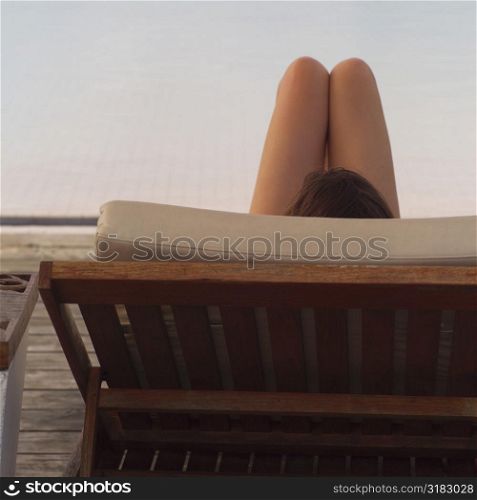 Woman relaxing in a chaise lounge chair