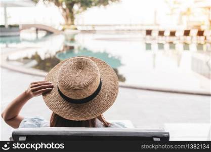 Woman relaxing in beautiful luxury hotel near swimming pool, summer holidays concept.