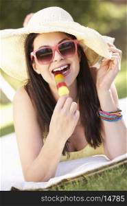 Woman Relaxing In Garden Eating Ice Lolly