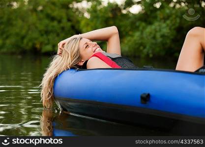 Woman relaxing in kayak in creek