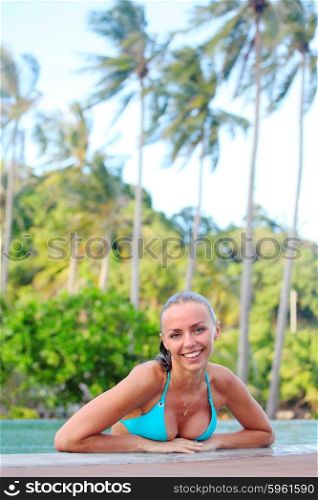 Woman relaxing in swimming pool. Woman relaxing in swimming pool and palm trees on background
