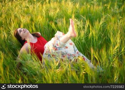 Woman relaxing in the meadow in summer sunset. High quality photo .. Woman relaxing in the meadow in summer sunset