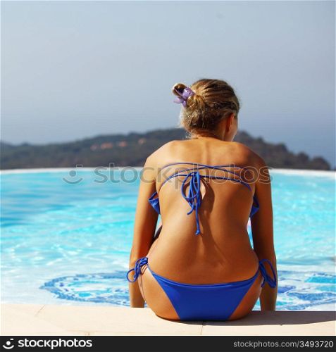 woman relaxing near swimming pool