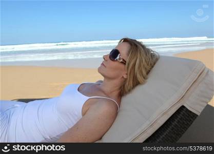 Woman relaxing on a sun lounger on the beach
