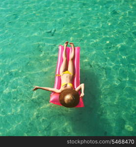 Woman relaxing on inflatable mattress at the beach