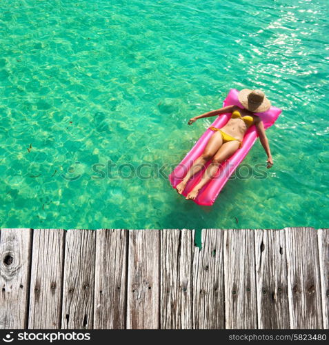 Woman relaxing on inflatable mattress at the beach