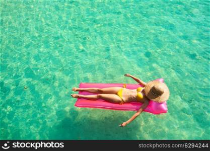 Woman relaxing on inflatable mattress at the beach