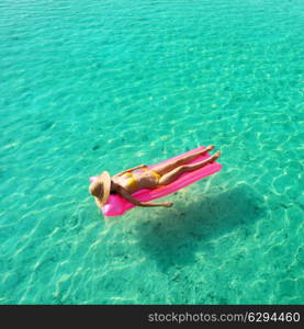 Woman relaxing on inflatable mattress at the beach