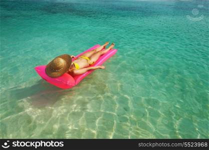 Woman relaxing on inflatable mattress near the beach