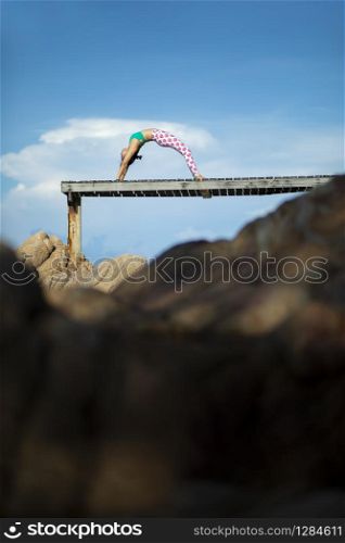 woman relaxing vacation playing yoga pose on beach pier