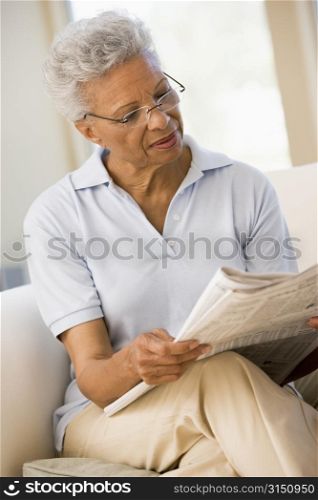 Woman relaxing with a newspaper smiling