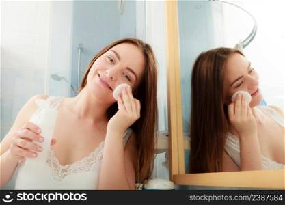 Woman removing makeup with cotton swab pad. Young girl taking care of skin. Skincare concept.. Woman removing makeup with cotton swab pad.