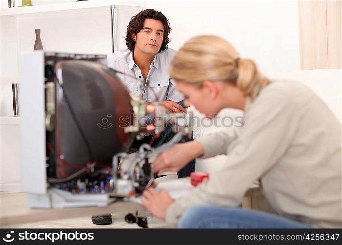 Woman repairing a television set