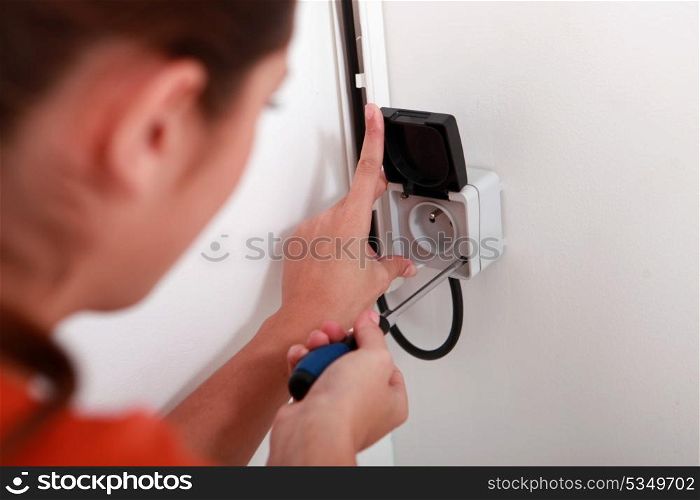 Woman repairing electrical socket