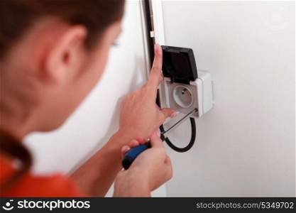 Woman repairing electrical socket