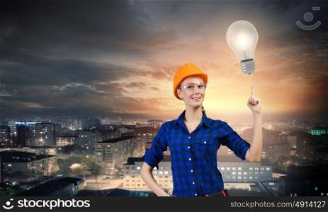 Woman repairman. Young woman handyman pointing at electrical bulb