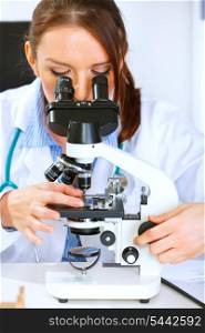 Woman researcher using microscope in medical laboratory. Close-up&#xA;