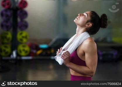 Woman Resting After Exercises In Gym with a white Towel. Woman Resting After Exercises at the Gym