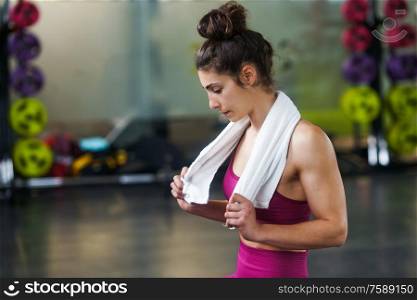 Woman Resting After Exercises In Gym with a white Towel. Woman Resting After Exercises at the Gym
