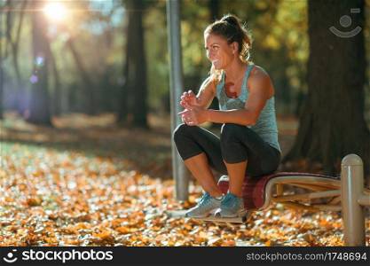 Woman Resting Ater Exercising Outdoors in The Fall In The Park
