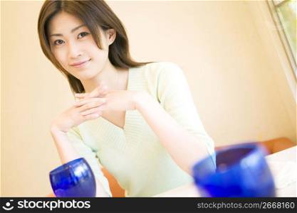 Woman resting her elbows on a table with smile