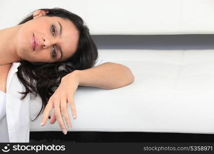 Woman resting her head against a piece of furniture