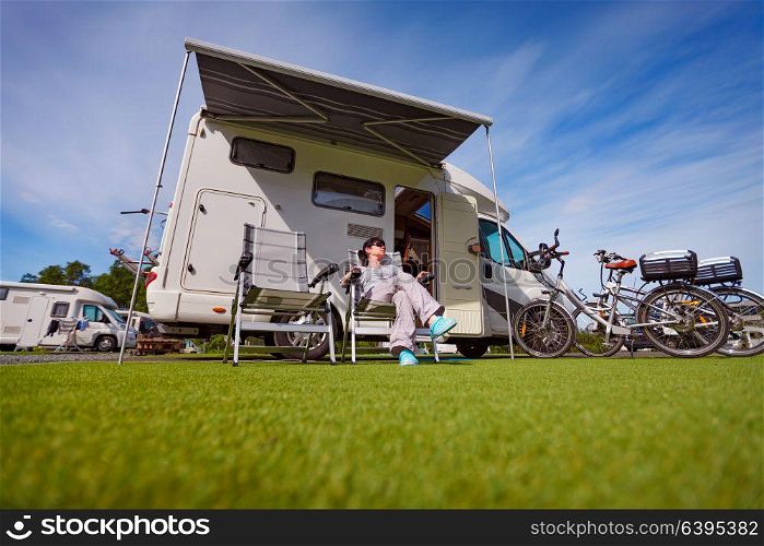 Woman resting near motorhomes in nature. Family vacation travel, holiday trip in motorhome RV, Caravan car Vacation.
