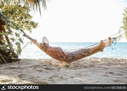 Woman resting on a hammock in a beach enjoying summer holiday