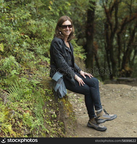 Woman resting on a rock at Tango Goemba, Thimphu, Bhutan