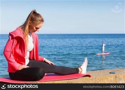 Woman resting relaxing after doing sports outdoors. Woman resting relaxing after doing sports outdoors. Fitness girl female in sportswear on seaside takes break